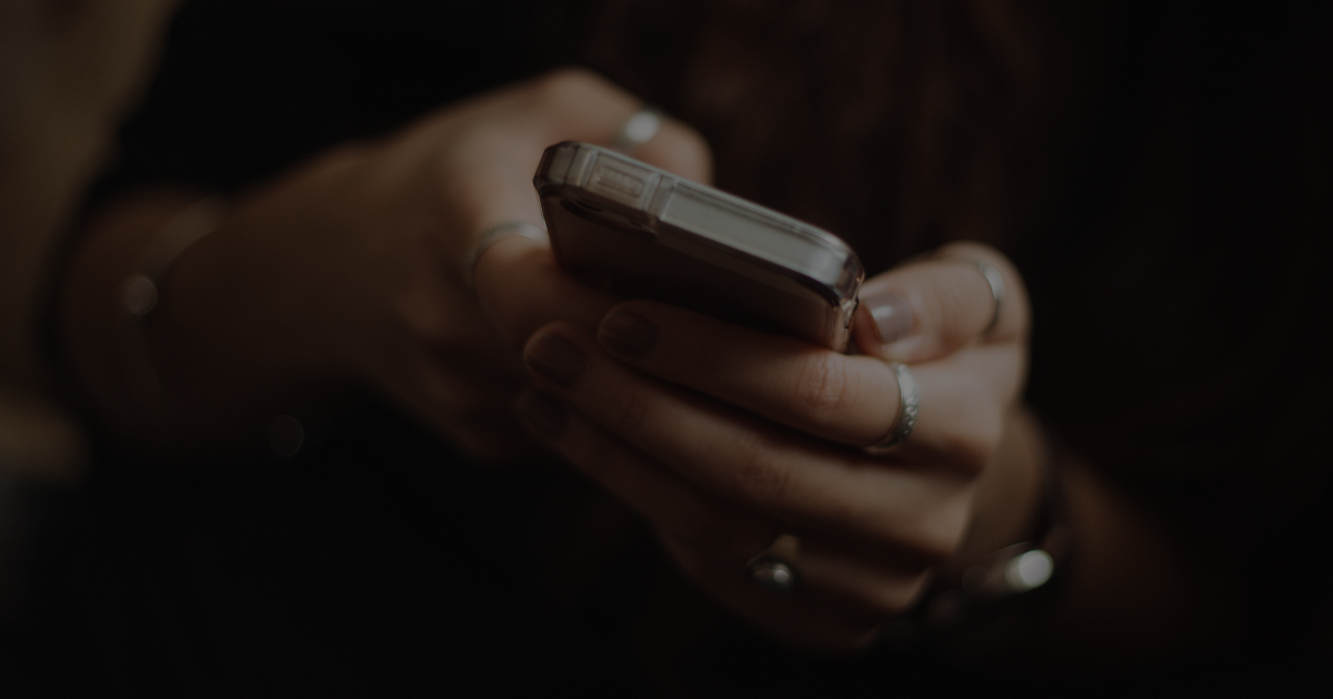 Image shows a person in the dark using their mobile phone to get help.
