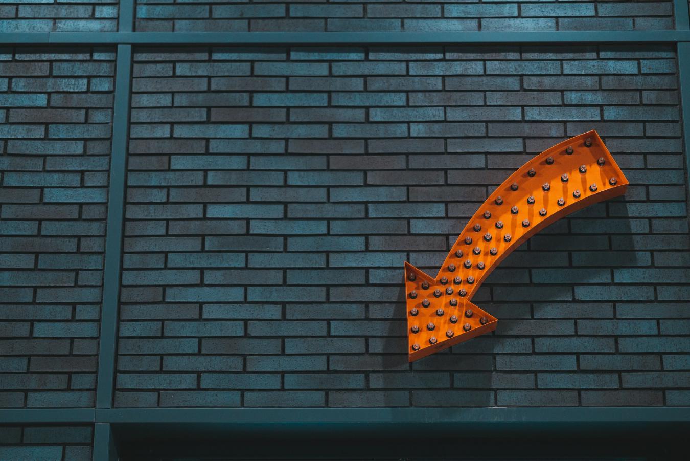 A photo of bricks with an orange arrow pointing towards the bottom.