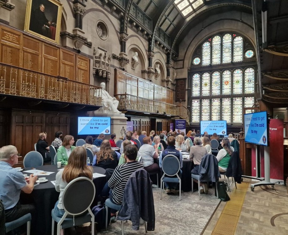 A photo of one of National Energy Action's fuel poverty forums. Many frontline workers are sat down watching a presentation showing the lived experience from one of our clients.