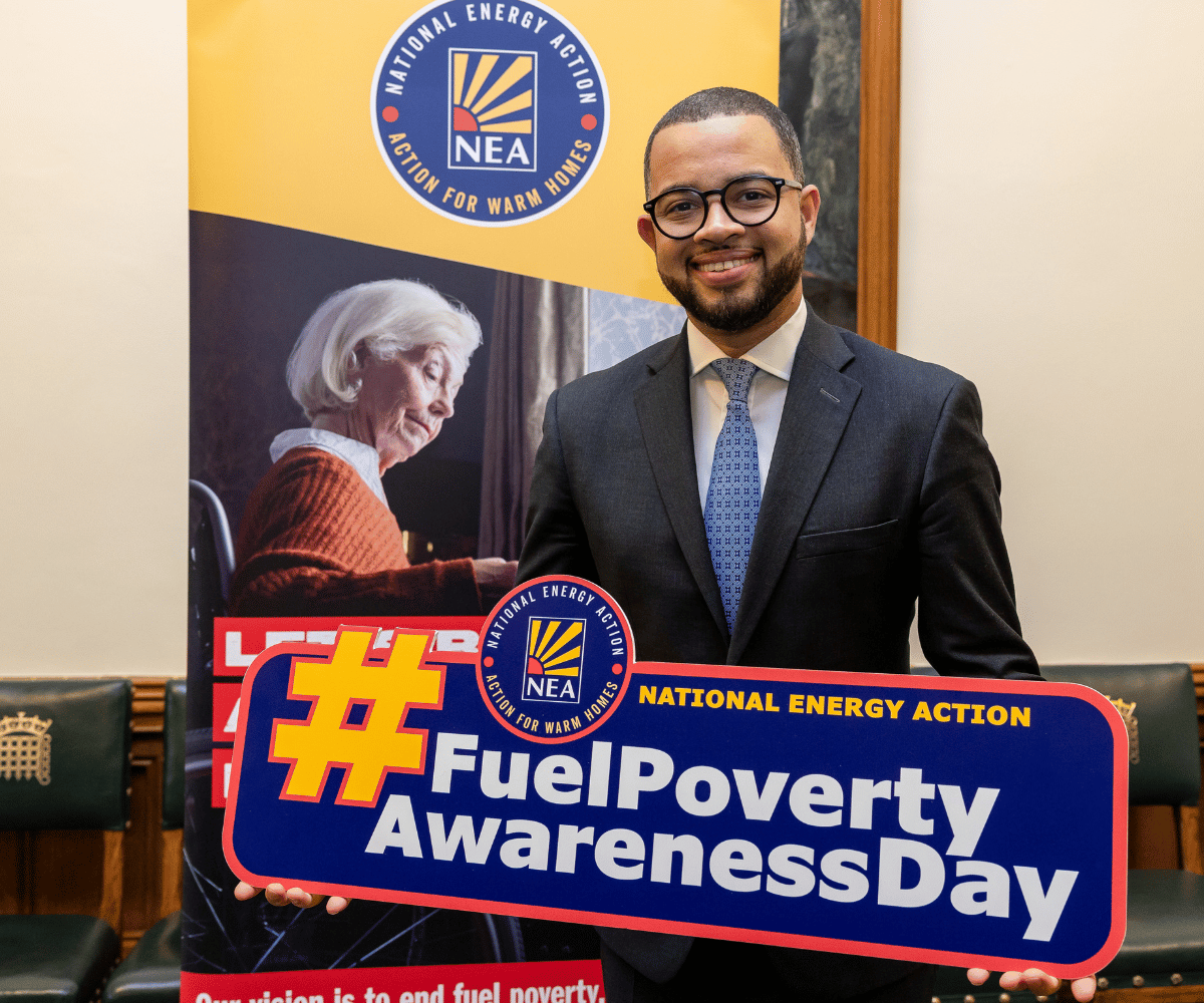 A photo of a Member of Parliament holding a sign that says, #FuelPovertyAwarenessDay'. It is supporting one of our campaigns.