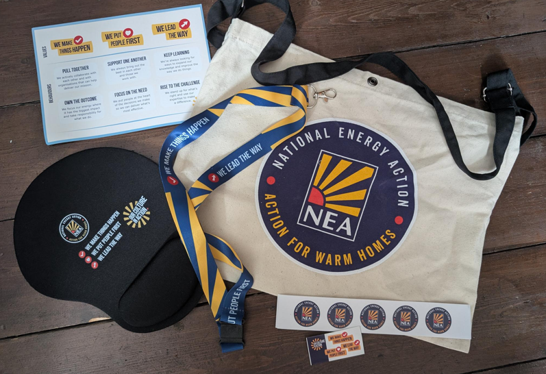 A photo of a tote bag and a mouse mat with National Energy Action's logo on it.