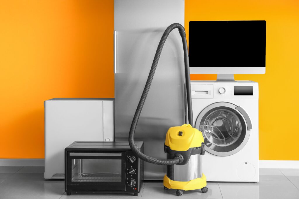 A selection of household appliances including a fridge, a microwave, a hoover and a washing machine. 