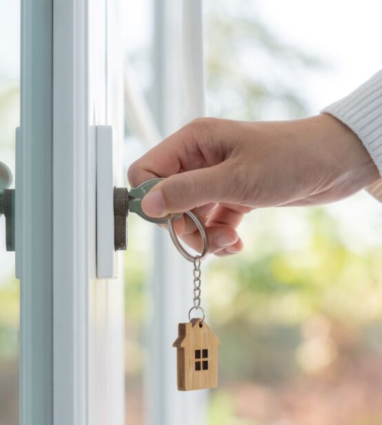 Stock photo of person's hand opening their new home with a key.