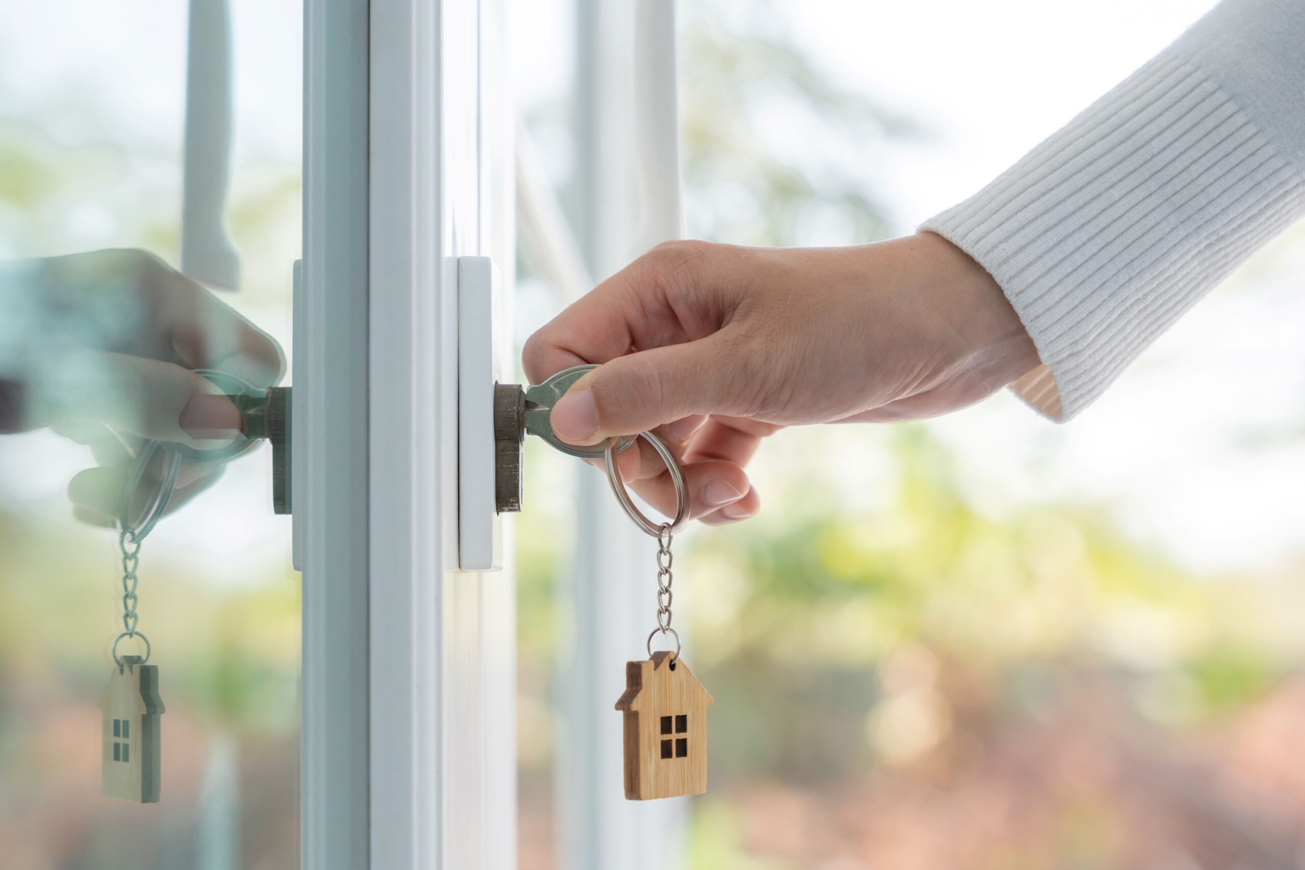 Stock photo of person's hand opening their new home with a key.