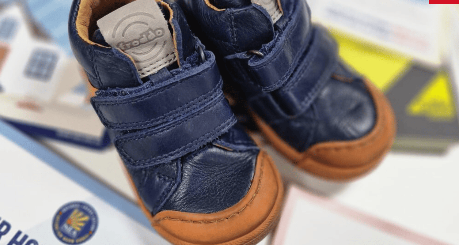 A photo of some children's shoes on top of some National Energy Action advice leaflets.