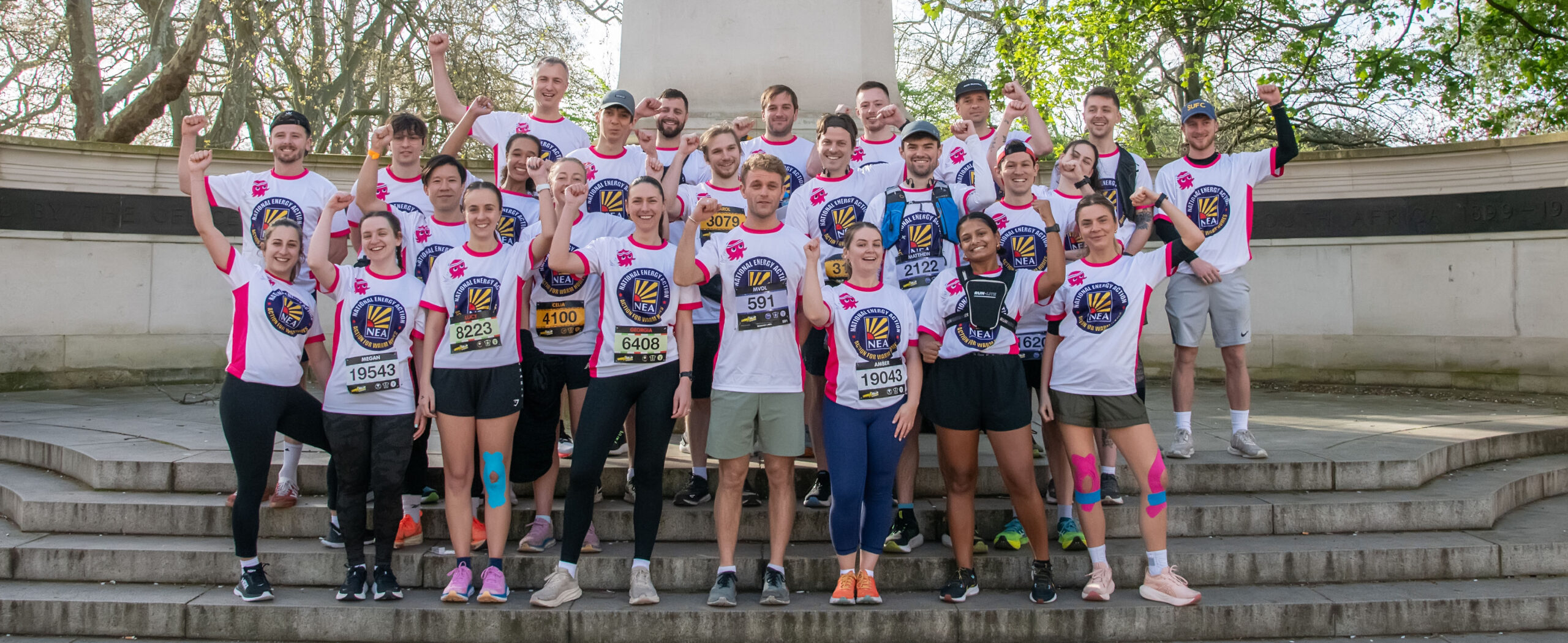 A photo of a large number of runners. They are wearing t-shirts with National Energy Action's logo on it after completing a run. They are fundraising for NEA.