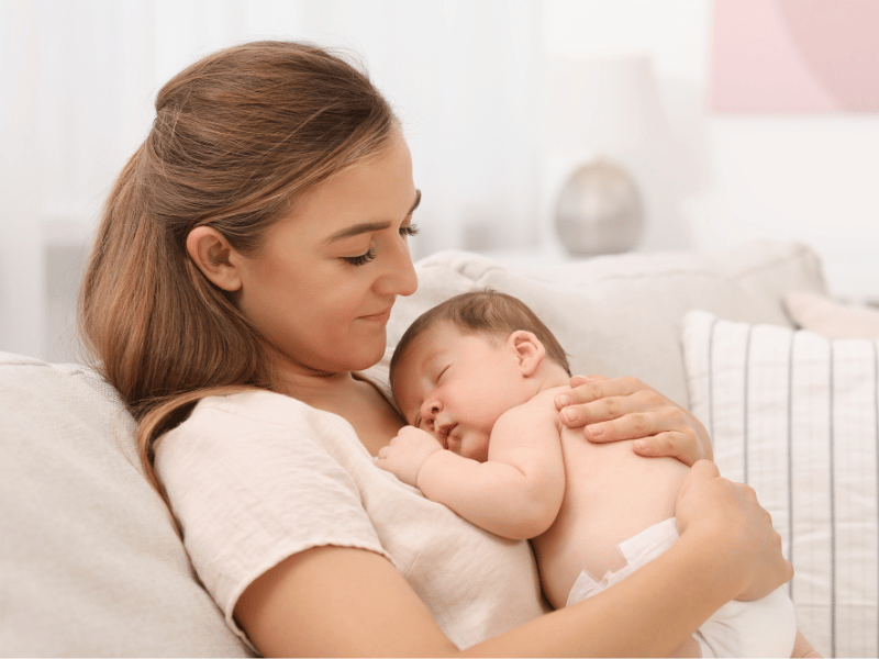 Newborn baby cuddled by mum