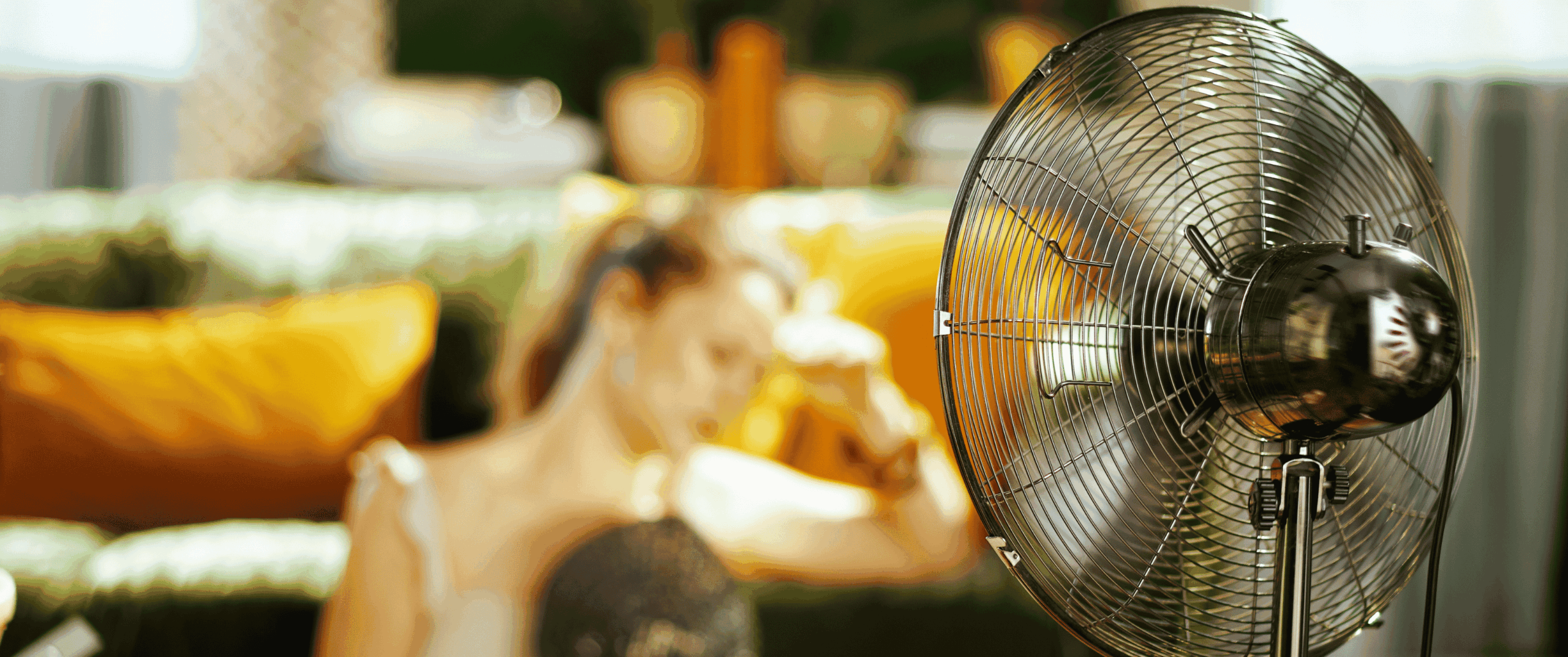 Fan blowing cold air on fatigued woman